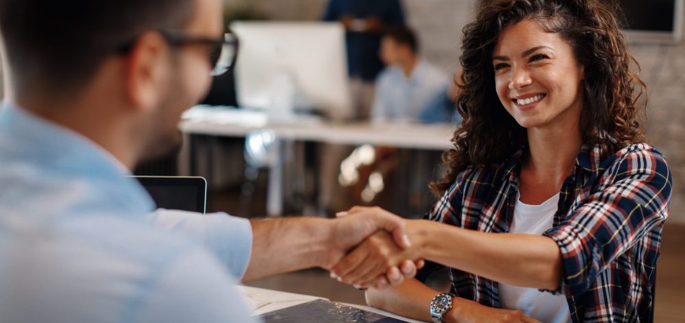 Young woman signing contracts and handshake with a manager